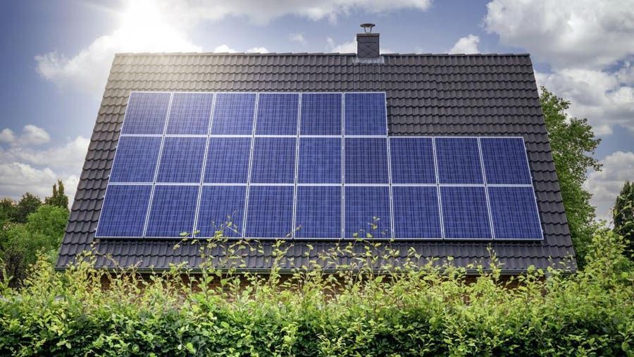 A house with a lot of solar panels on the roof.