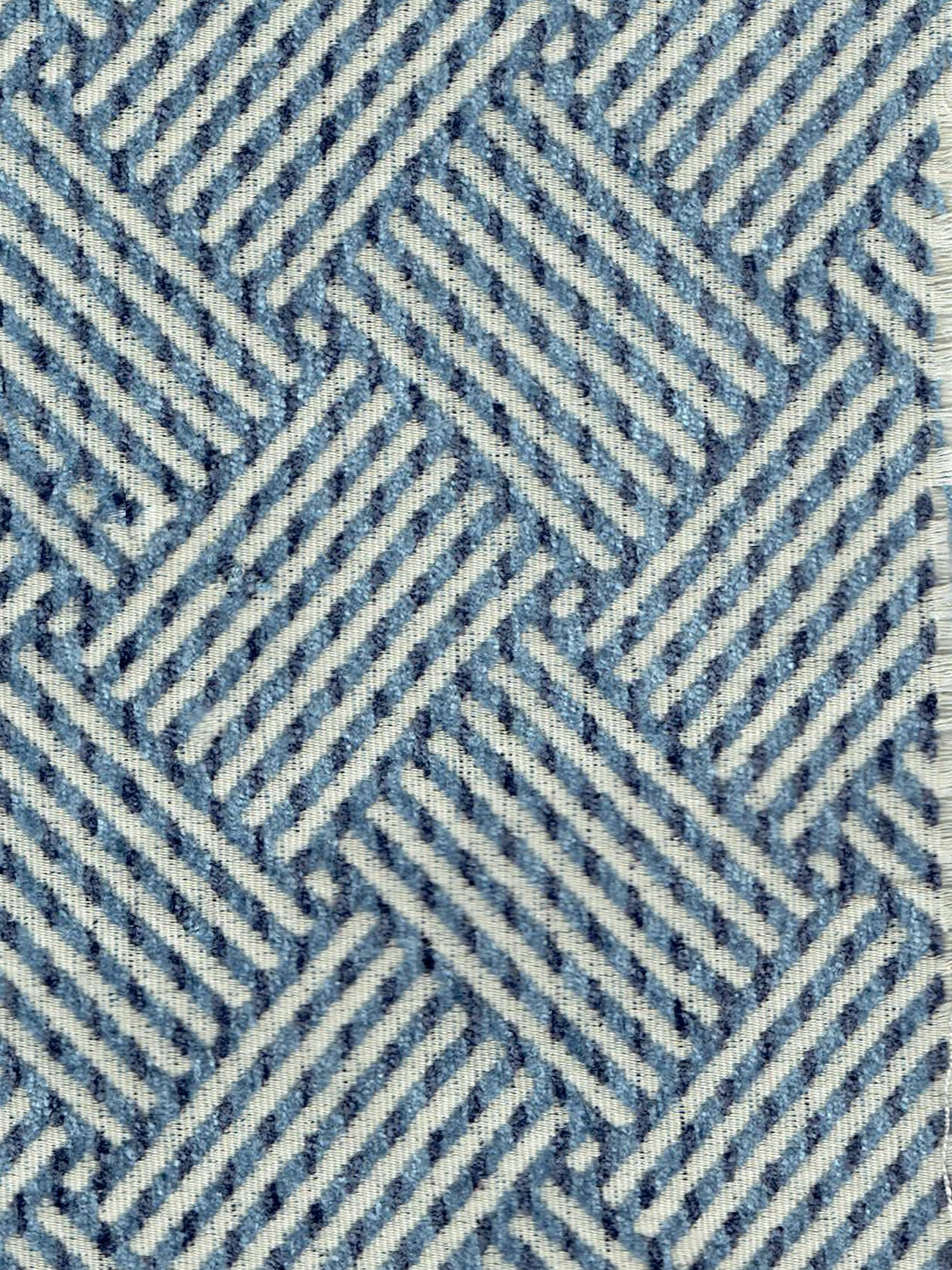 A close up of a blue and white striped fabric with a geometric pattern.