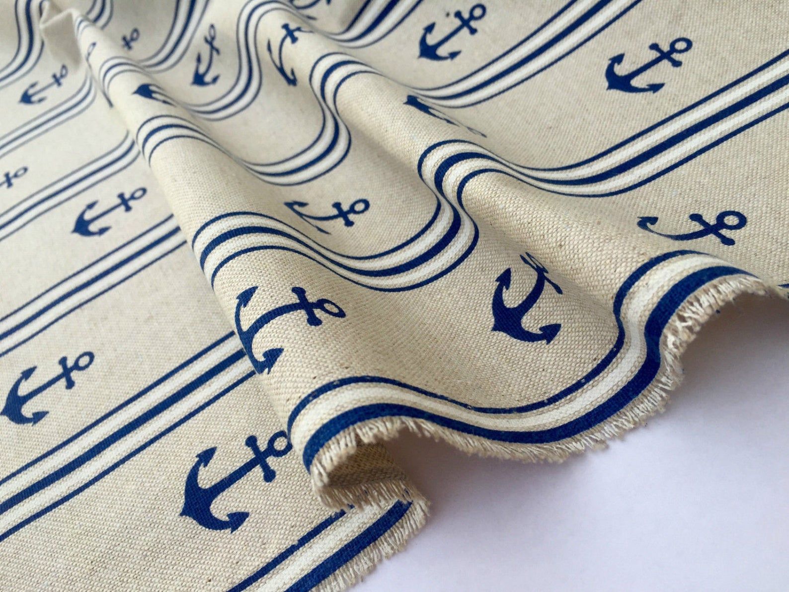 A piece of fabric with blue and white stripes and anchors on it