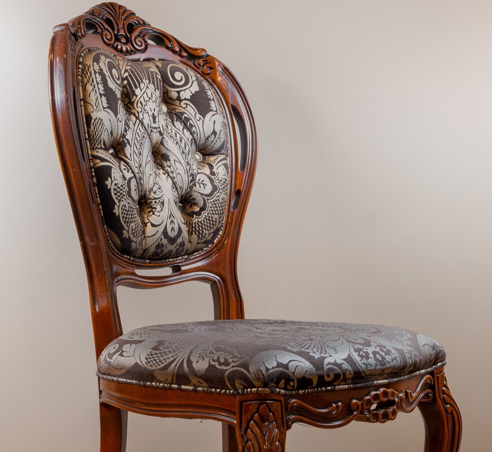 A wooden chair with a floral pattern on the back