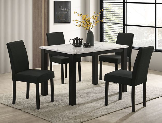 Black dining table with four chairs in a modern room, set with a vase of yellow flowers.