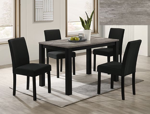 Modern dining table with four black chairs in a bright room, set on a light rug.