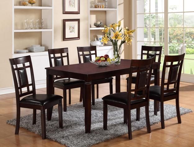 Dining room with dark wood table and six chairs, a vase of yellow flowers, and a bright window backdrop