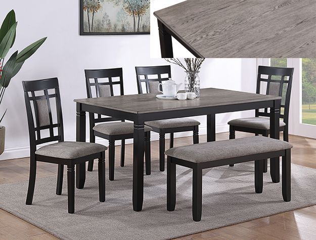 Dining table set with four chairs and two benches on a gray rug in a bright living room