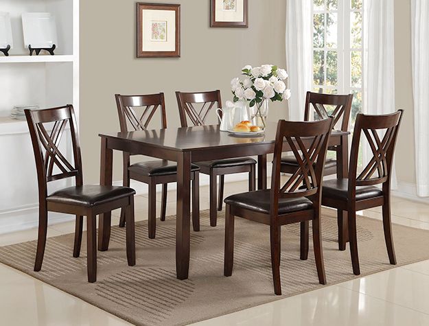 Dark wood dining table with six chairs in a bright, beige dining room with flowers and a window