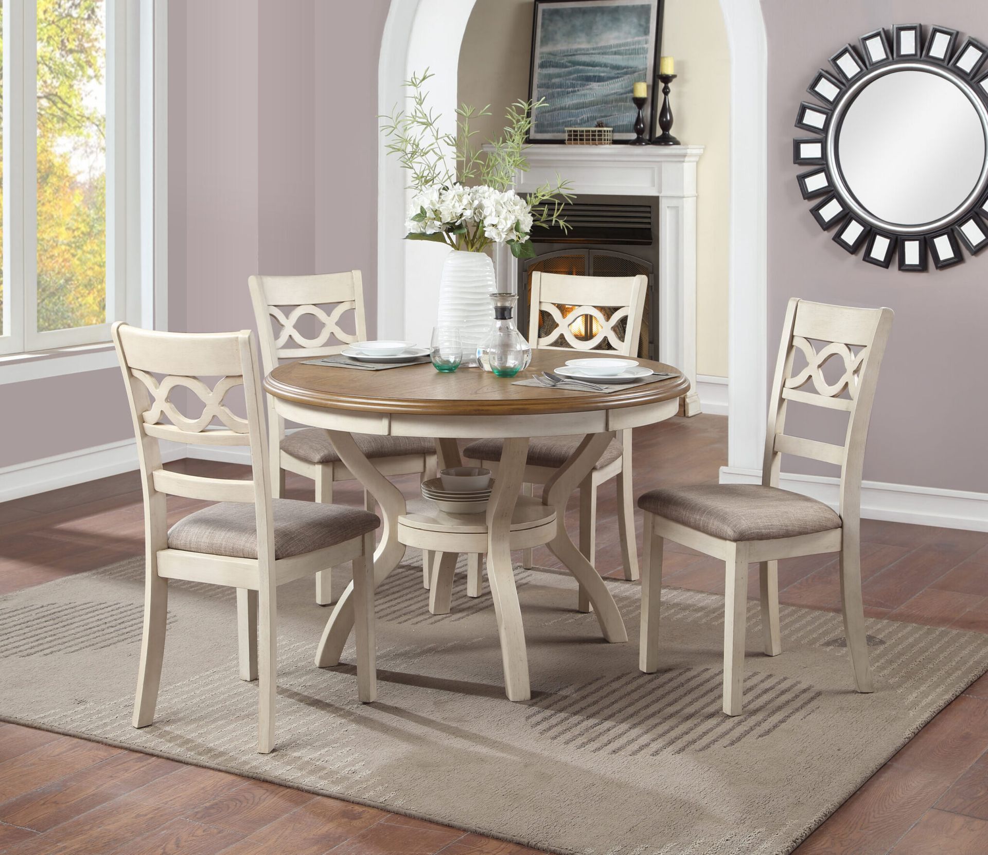Round dining table with four white chairs in a bright, neutral-toned dining room