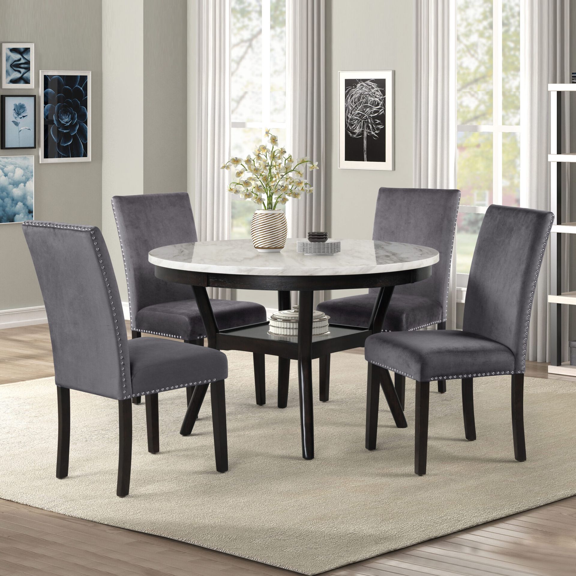 Gray dining set with round table and four upholstered chairs in a bright room
