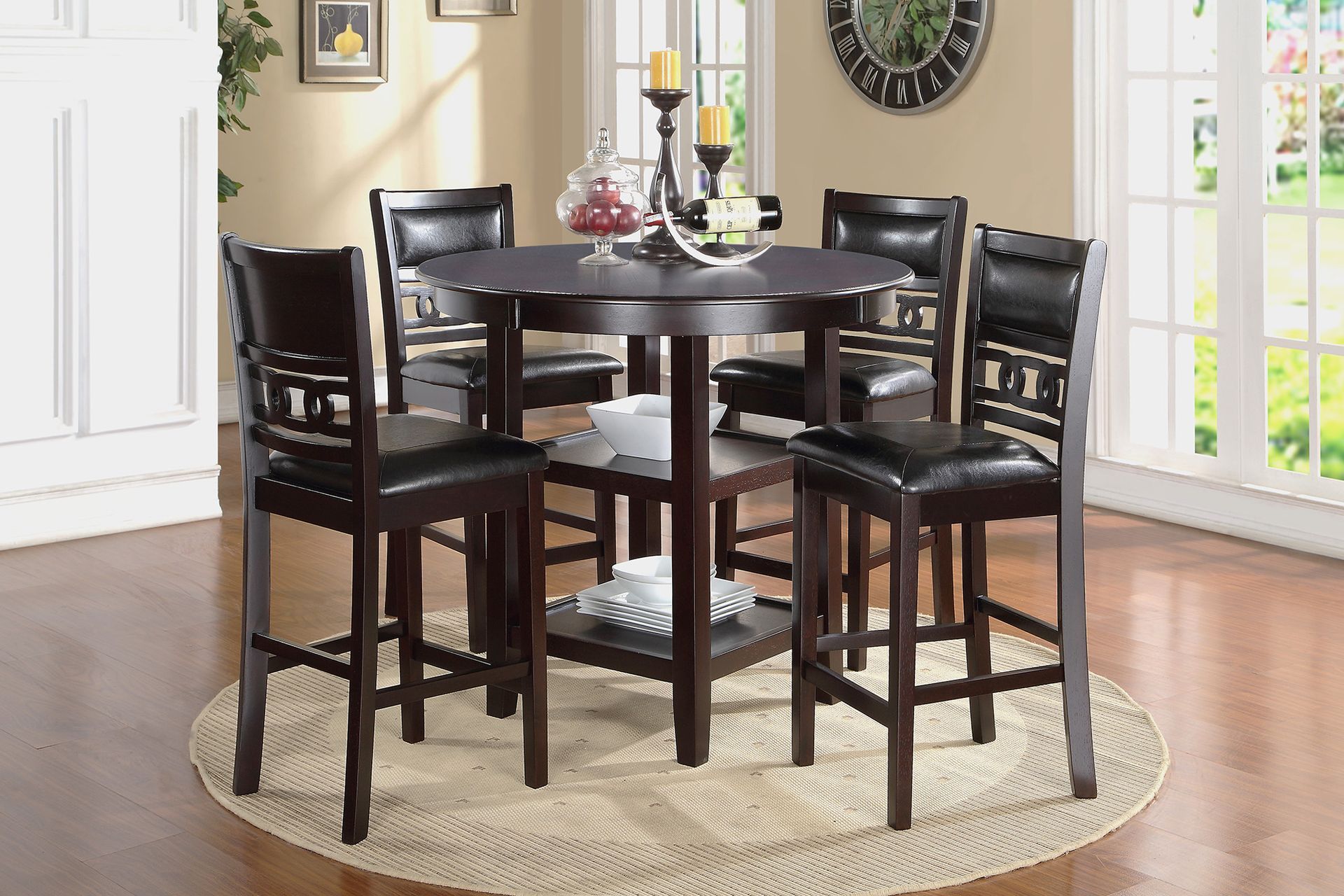 Dark wood dining table set with four chairs on a round rug in a bright room