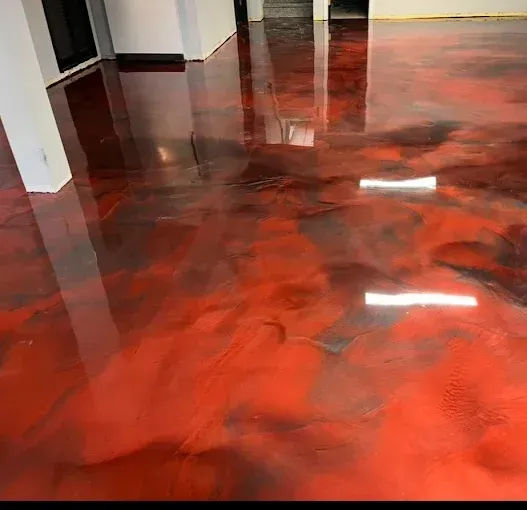 Red and black metallic epoxy flooring in a room, reflecting light.