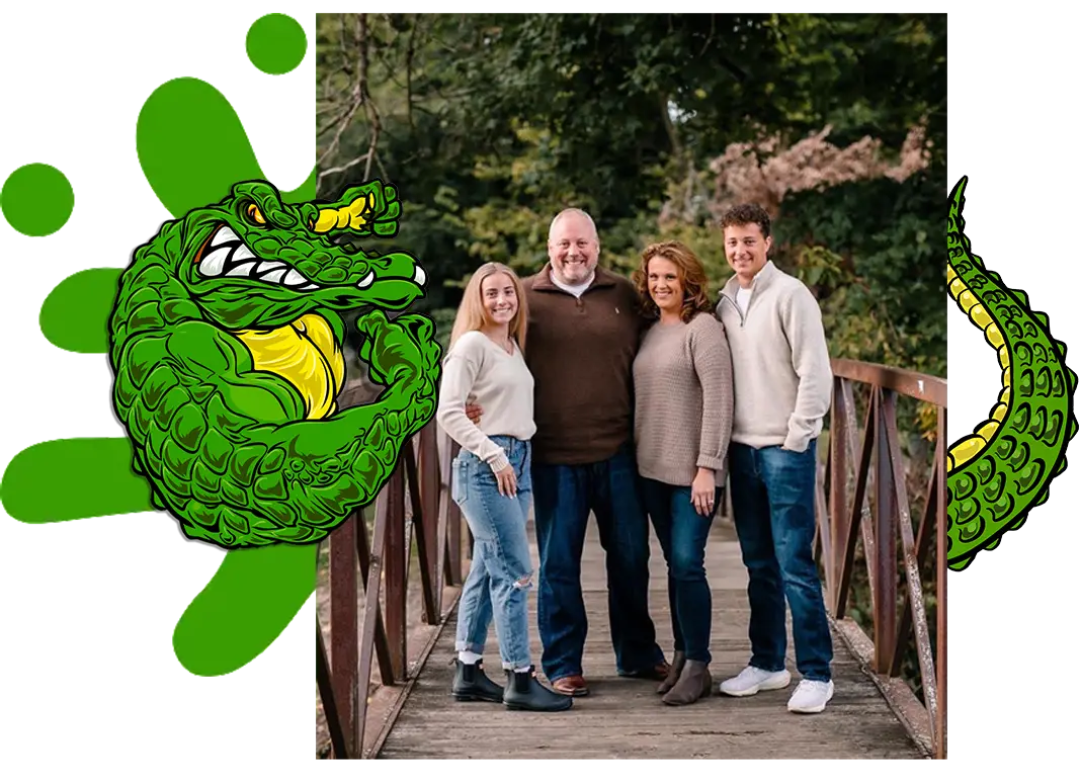 Family of four on a bridge; green cartoon alligator on the left and right.