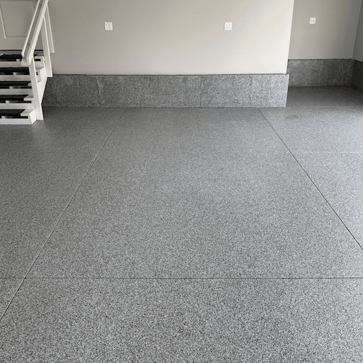 Gray speckled garage floor with gray baseboard and light gray walls.