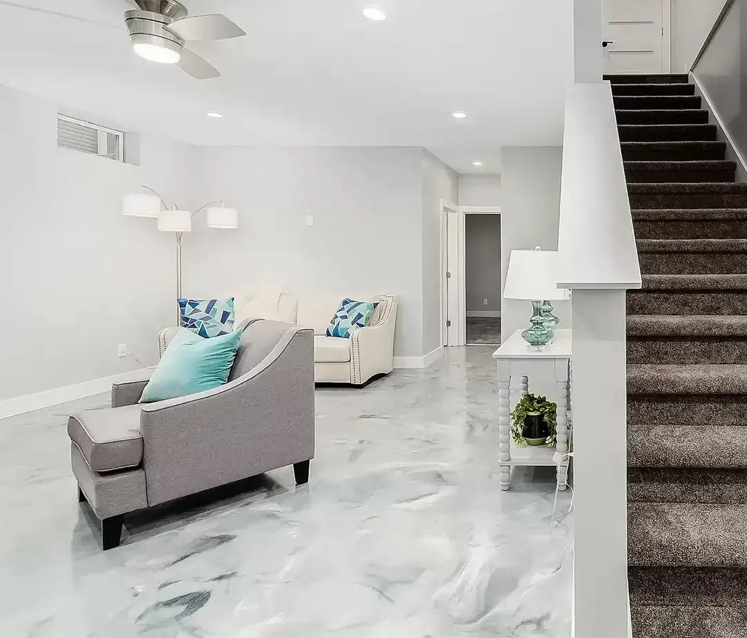 Person with paint roller applying sealant to a concrete floor.