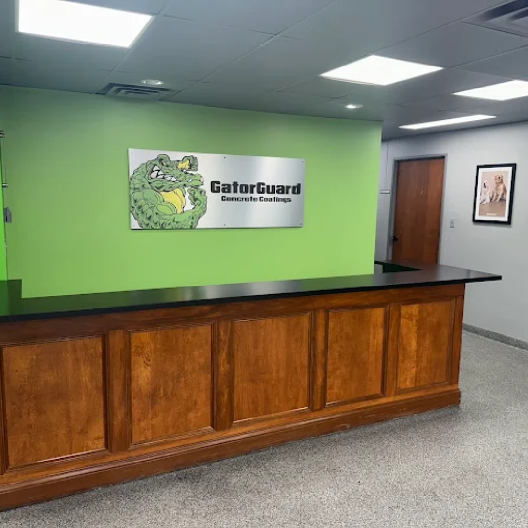 Reception desk with GatorGuard logo on green wall.