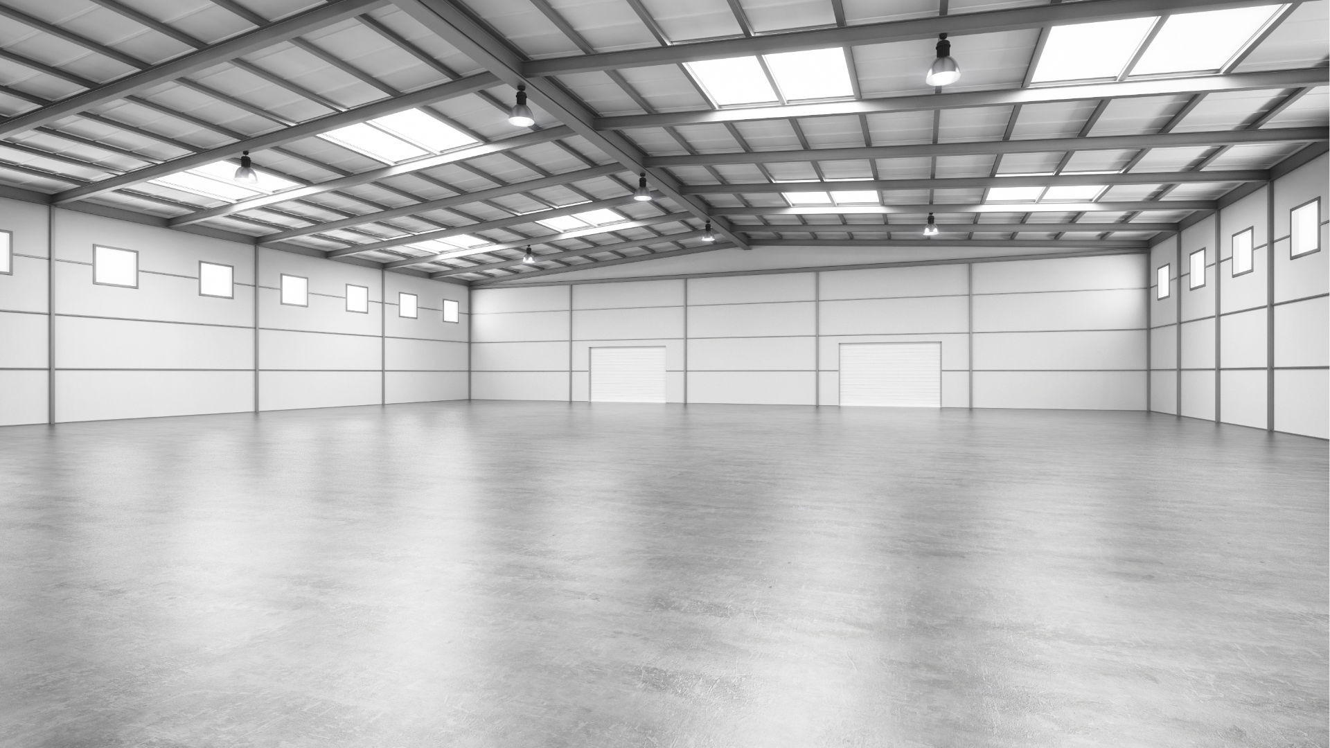 Empty, modern warehouse interior with white walls, concrete floor, and skylights.