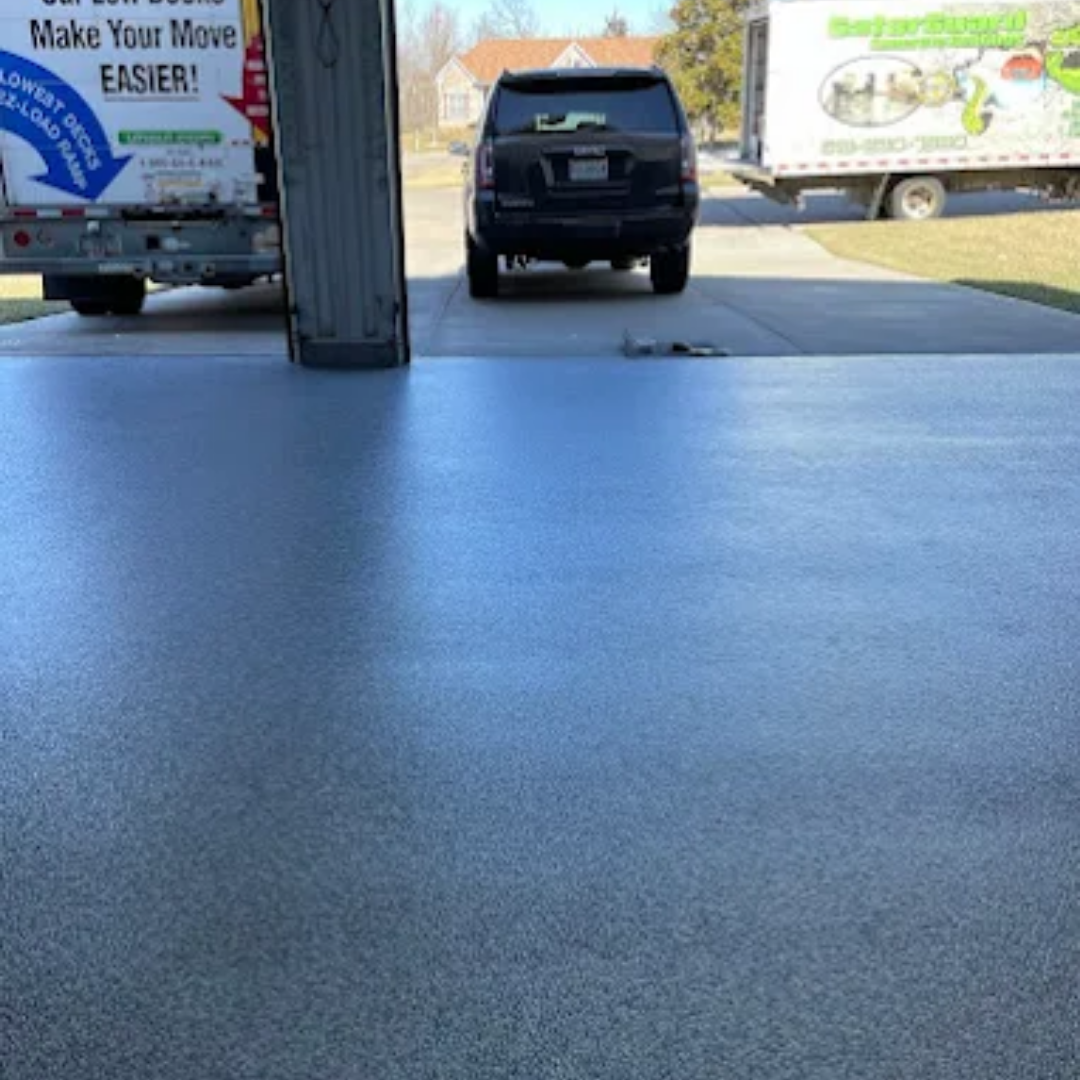 Garage with a shiny, blue-gray floor, a black SUV, and moving trucks.