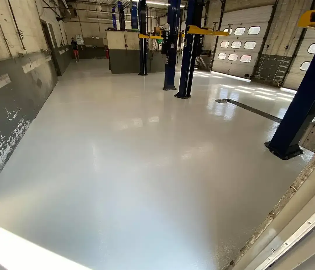 Stainless steel tanks in a brewery with a red floor and a ladder.