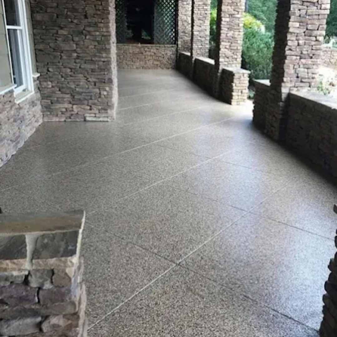 Covered porch with stone columns and gray, speckled concrete floor.