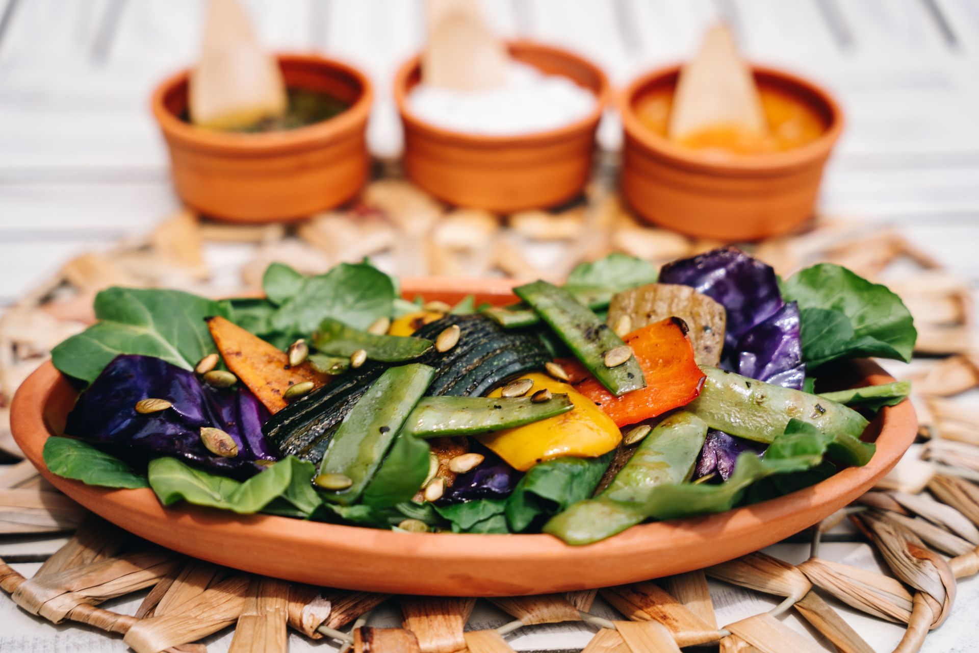 Grilled colorful vegetables with three dips.