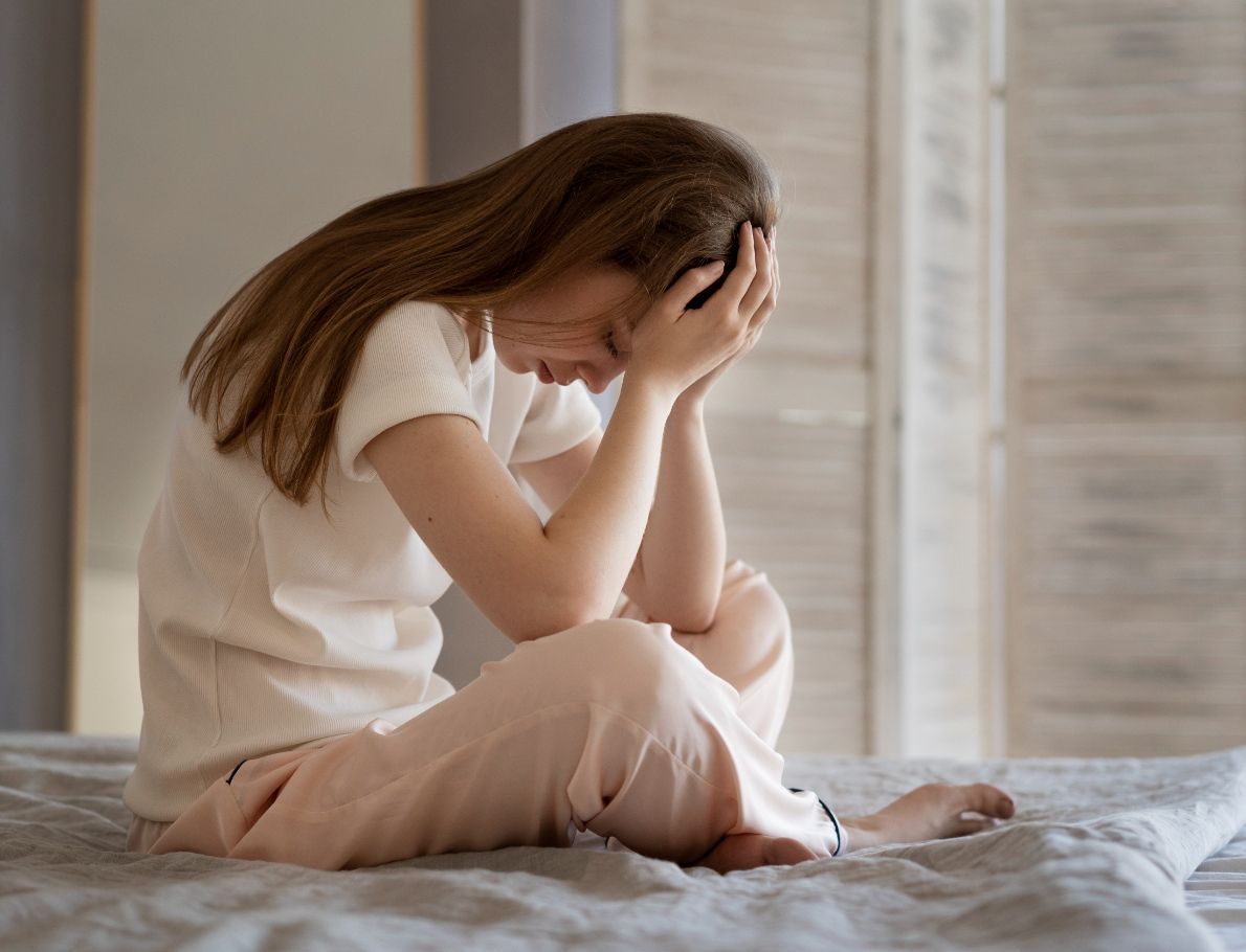 anxious-woman-sitting-bed-full-shot