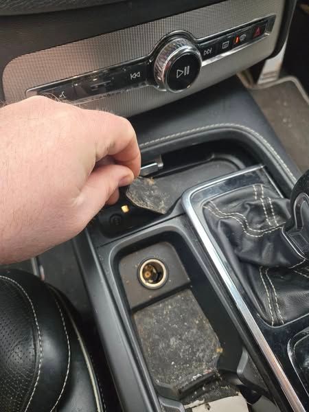 A close up of the dashboard of a car with a dirty shifter.