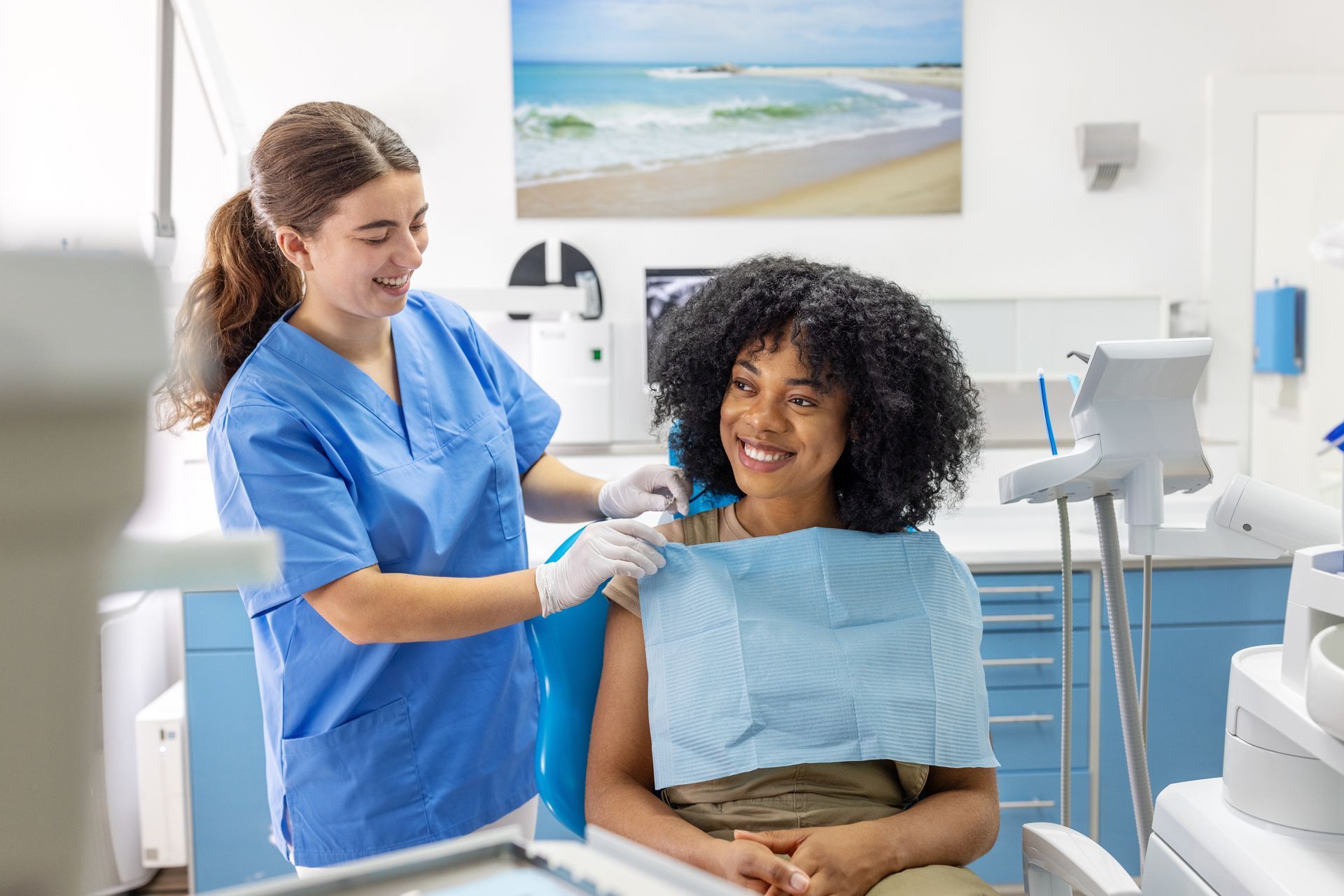 Dental assistant getting patient ready for detailed dental examination Dental assistant getting patient ready for detailed dental examination