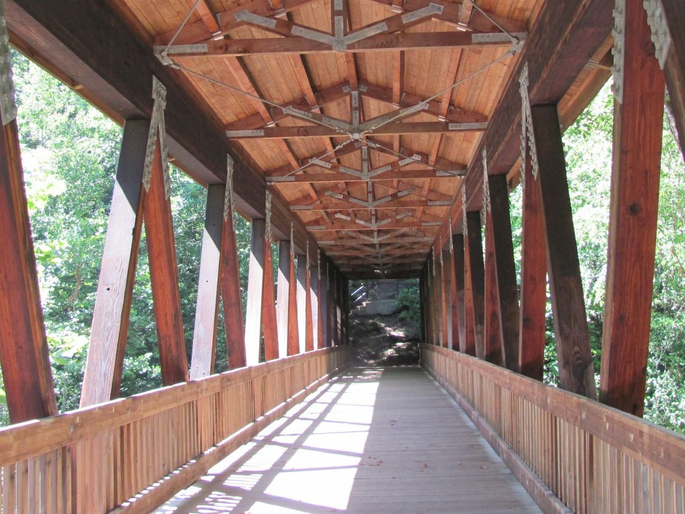 The inside of a wooden bridge with trees in the background