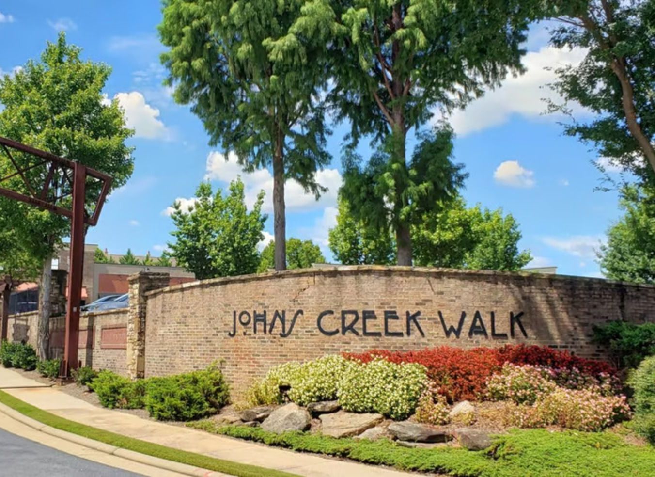 A sign for jenny creek walk is surrounded by trees and bushes.