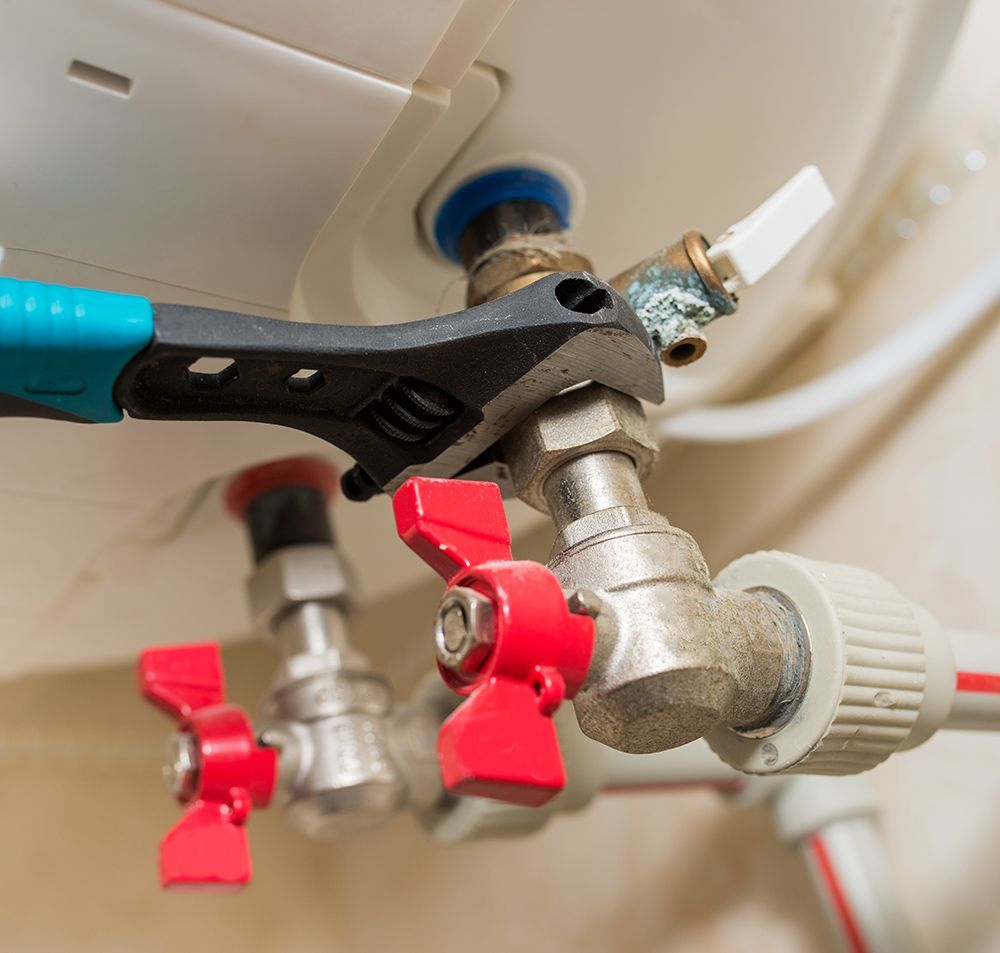 a wrench is being used to fix a water heater