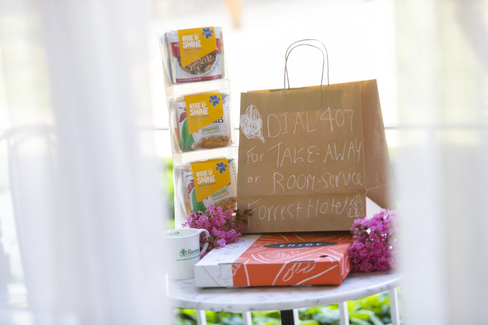 A takeout order on a table: food boxes, brown paper bag labeled 