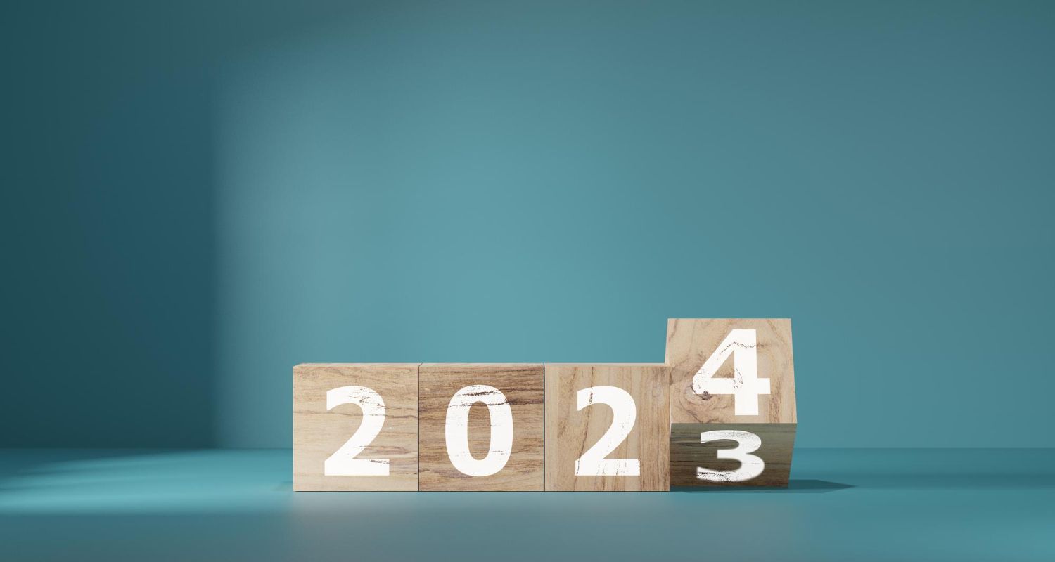 Wooden blocks with the numbers 2024 and 2023 on a blue background.