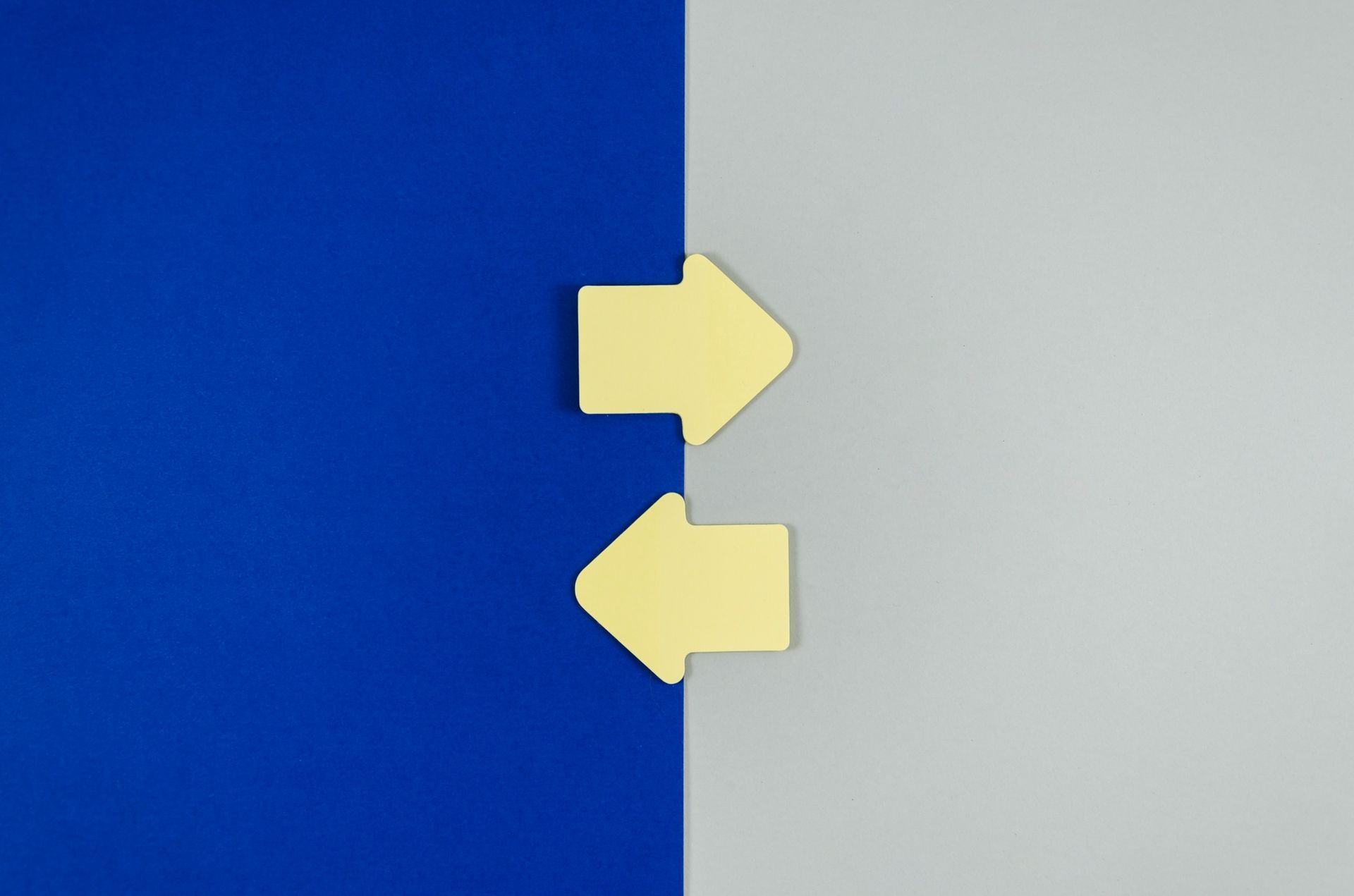 Two yellow arrows are pointing in opposite directions on a blue and gray background.