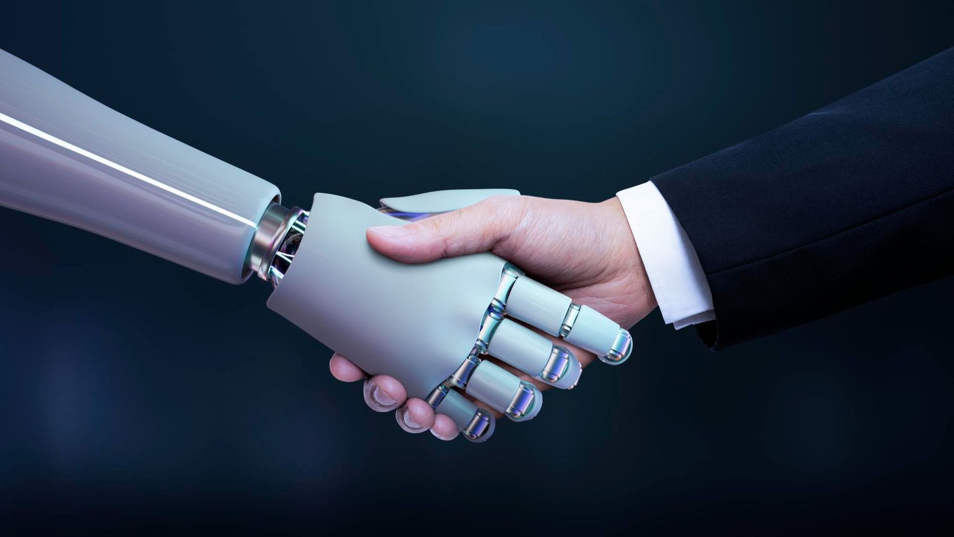 A man and a robot are shaking hands.