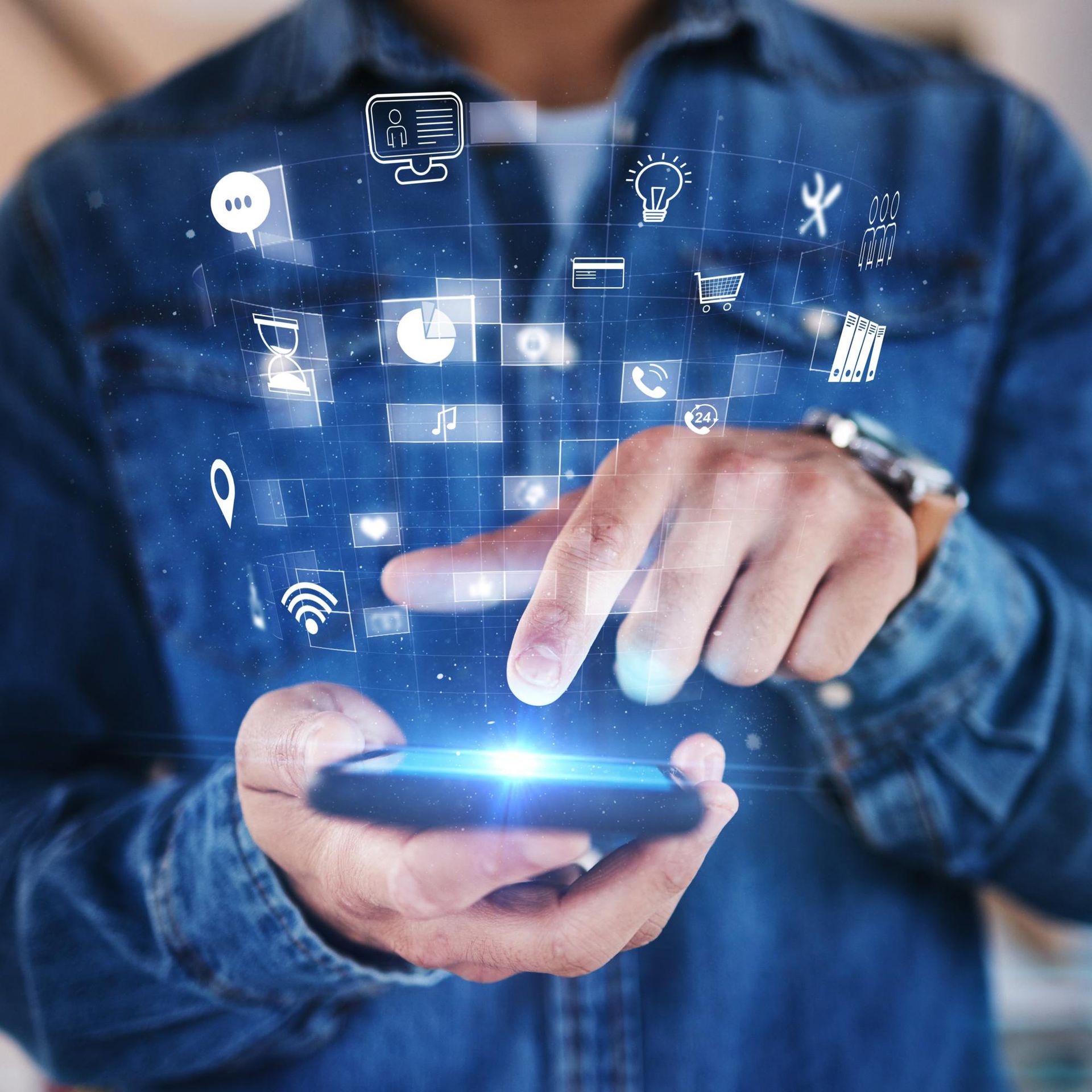 A man is using a smart phone with icons coming out of it
