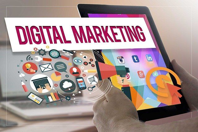 A person is holding a tablet with the word digital marketing on it.