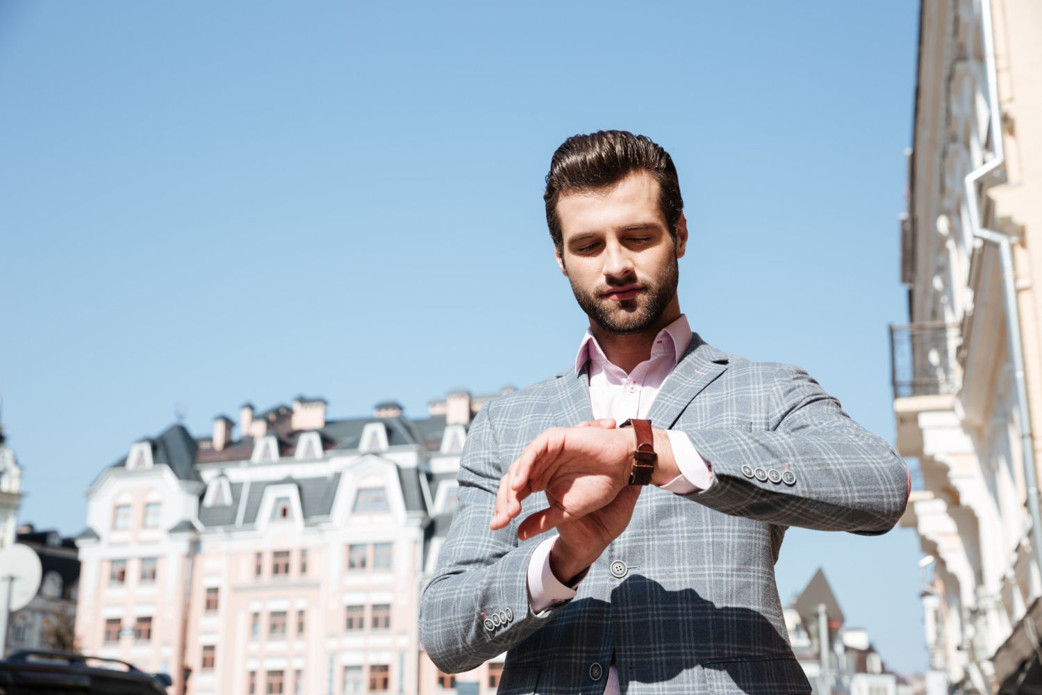 A man in a suit is looking at his watch.