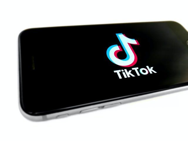 A cell phone with the tiktok logo on the screen