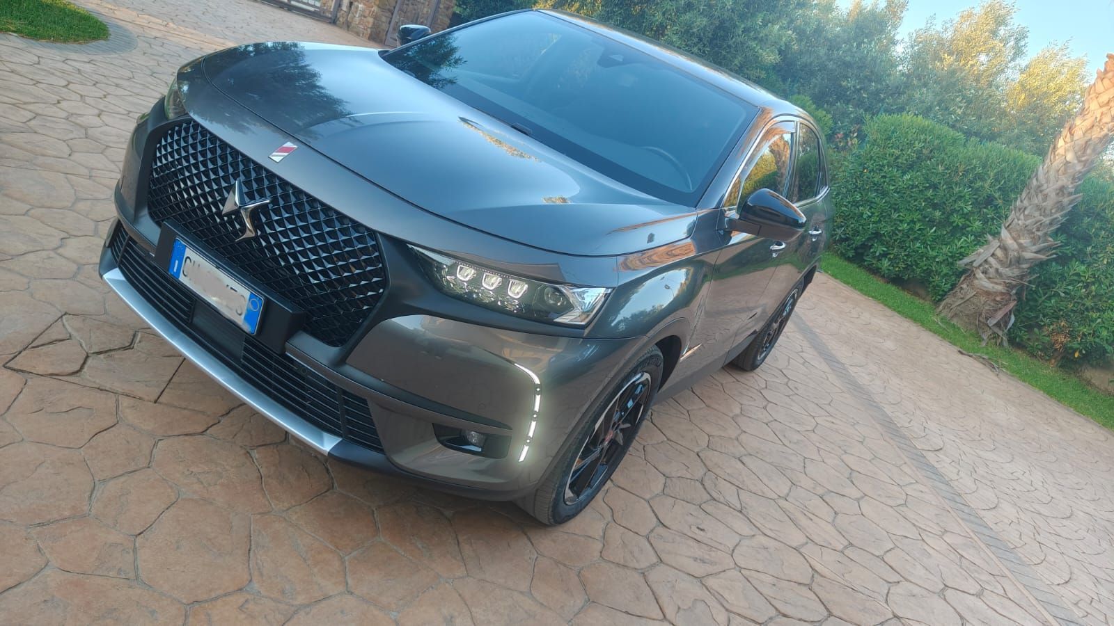 SUV Fiat 500L blu in uno showroom, vista frontale angolata. Ha fari rotondi e paraurti anteriore argentato.