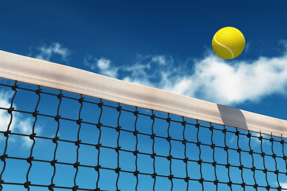 Stock image of tennis ball flying over the net