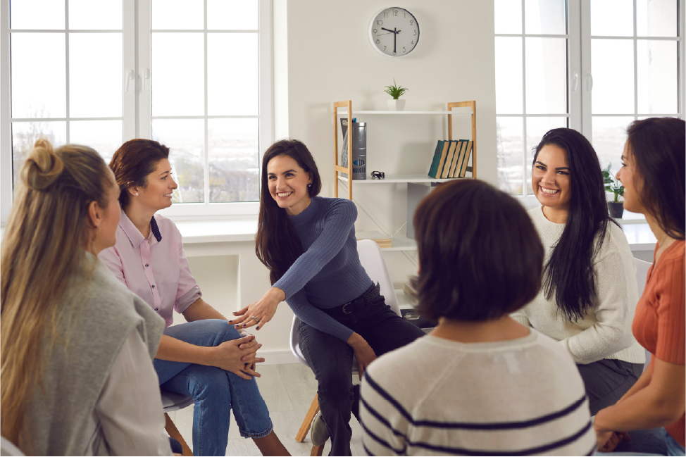 Eine Gruppe von Frauen sitzt im Kreis und unterhält sich.