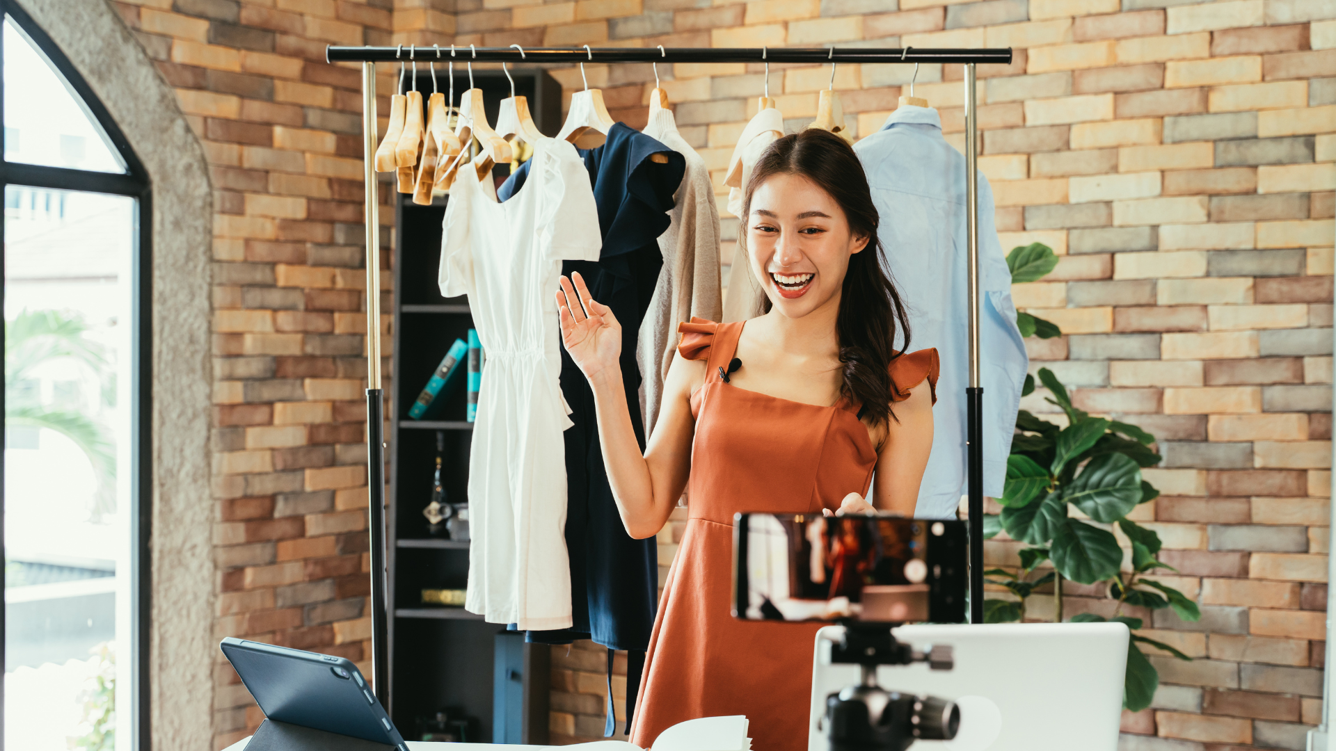 Image of an influencer speaking in front of a camera, showcasing Rawlings Media's expertise in influencer marketing. The background includes a clothing rack, symbolizing the company's collaboration with fashion brands and their ability to create engaging content for fashion influencers.