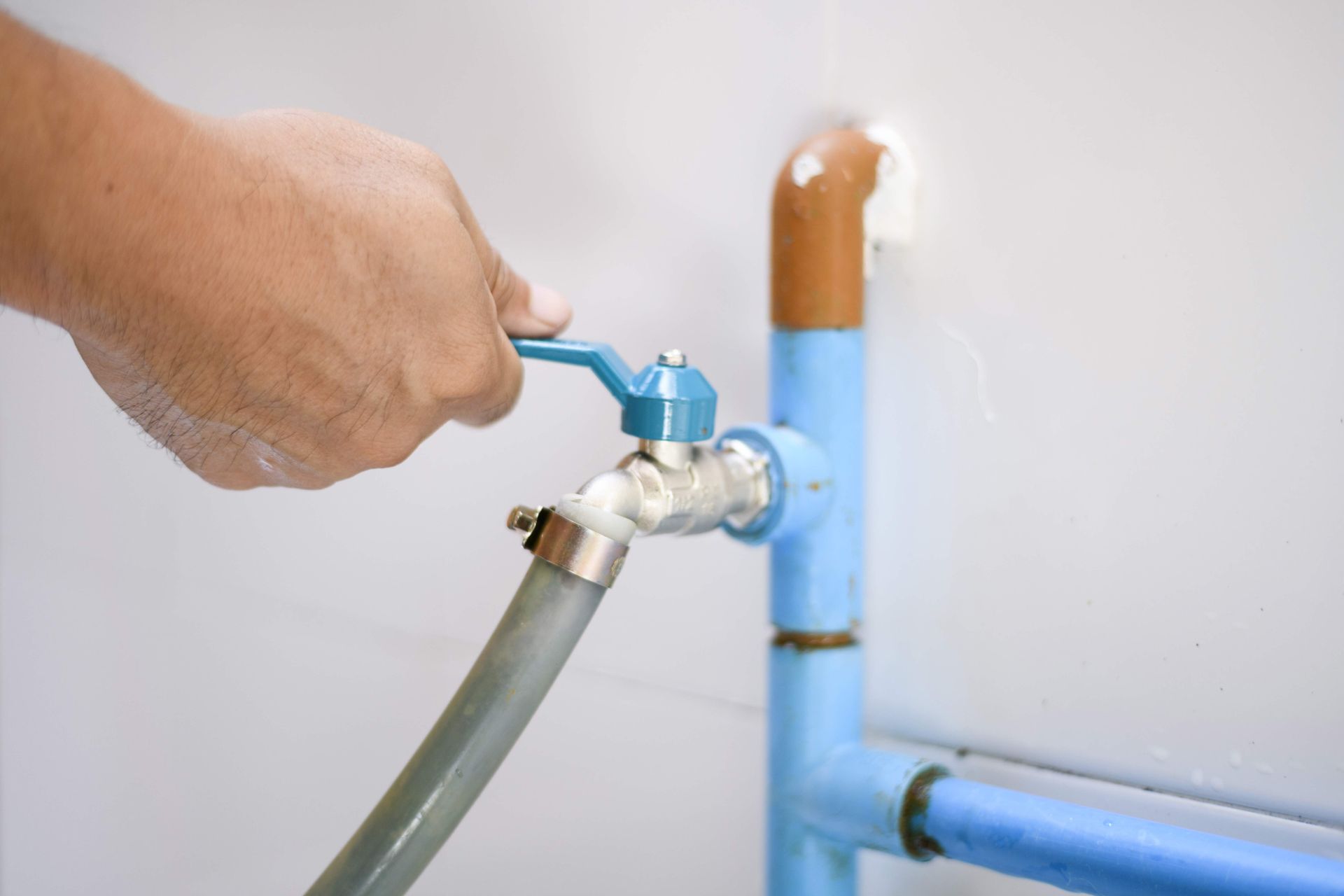 Plumber opening faucet after water line replacement services.