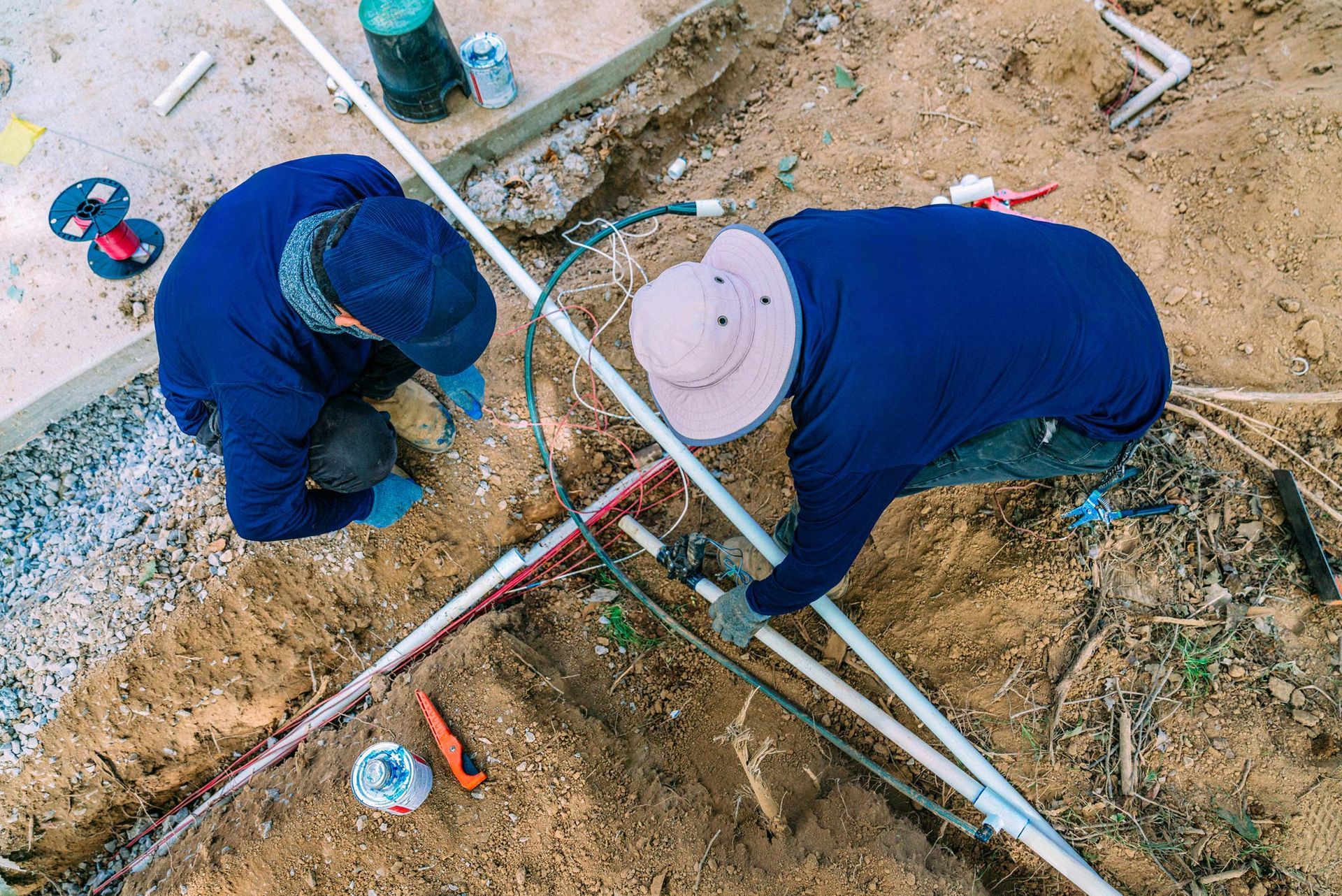 Specialists working on water line replacement services outside a residential property.