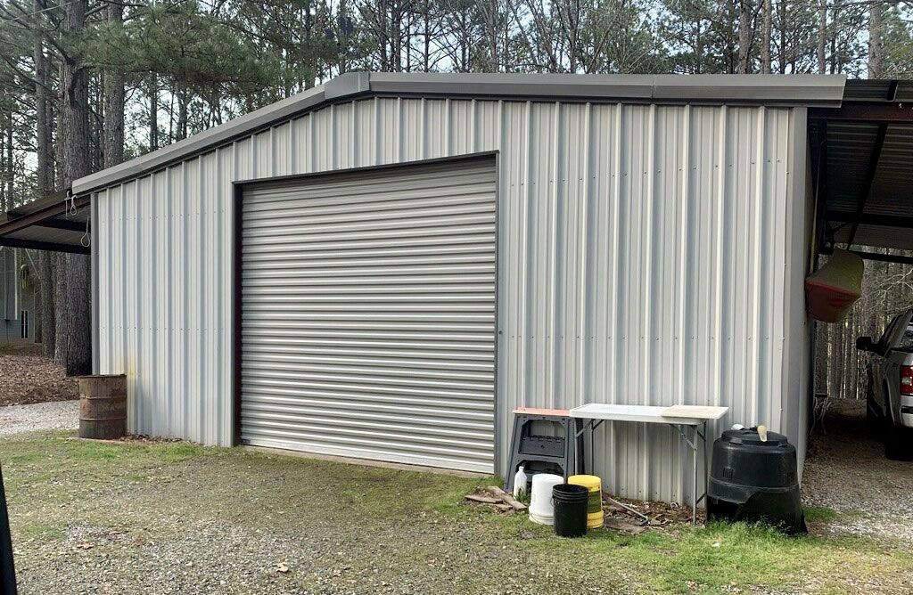 A metal garage with a table and chairs in front of it.