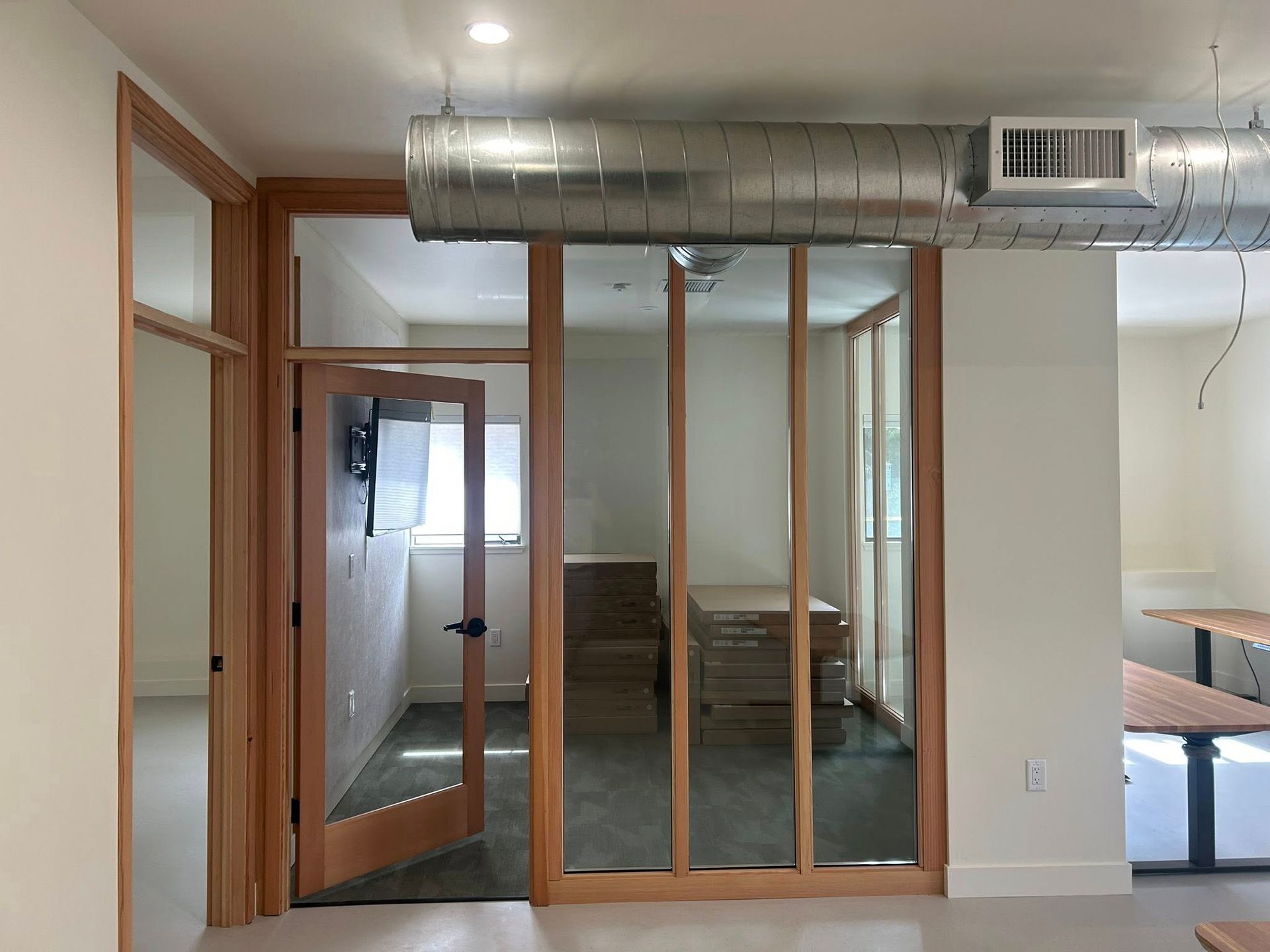 Interior room undergoing renovation, with exposed wooden framing and debris on the floor.