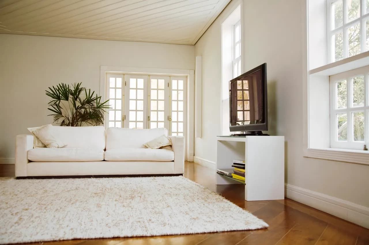 A living room with a white couch and a flat screen tv