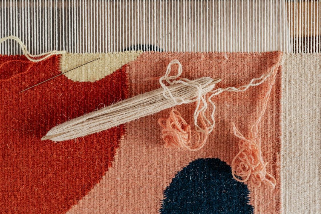 A close up of a rug being made on a loom.