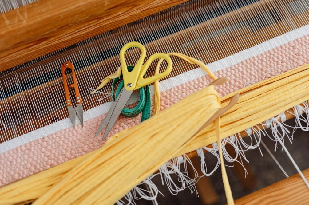 A pair of scissors sitting on top of a loom.