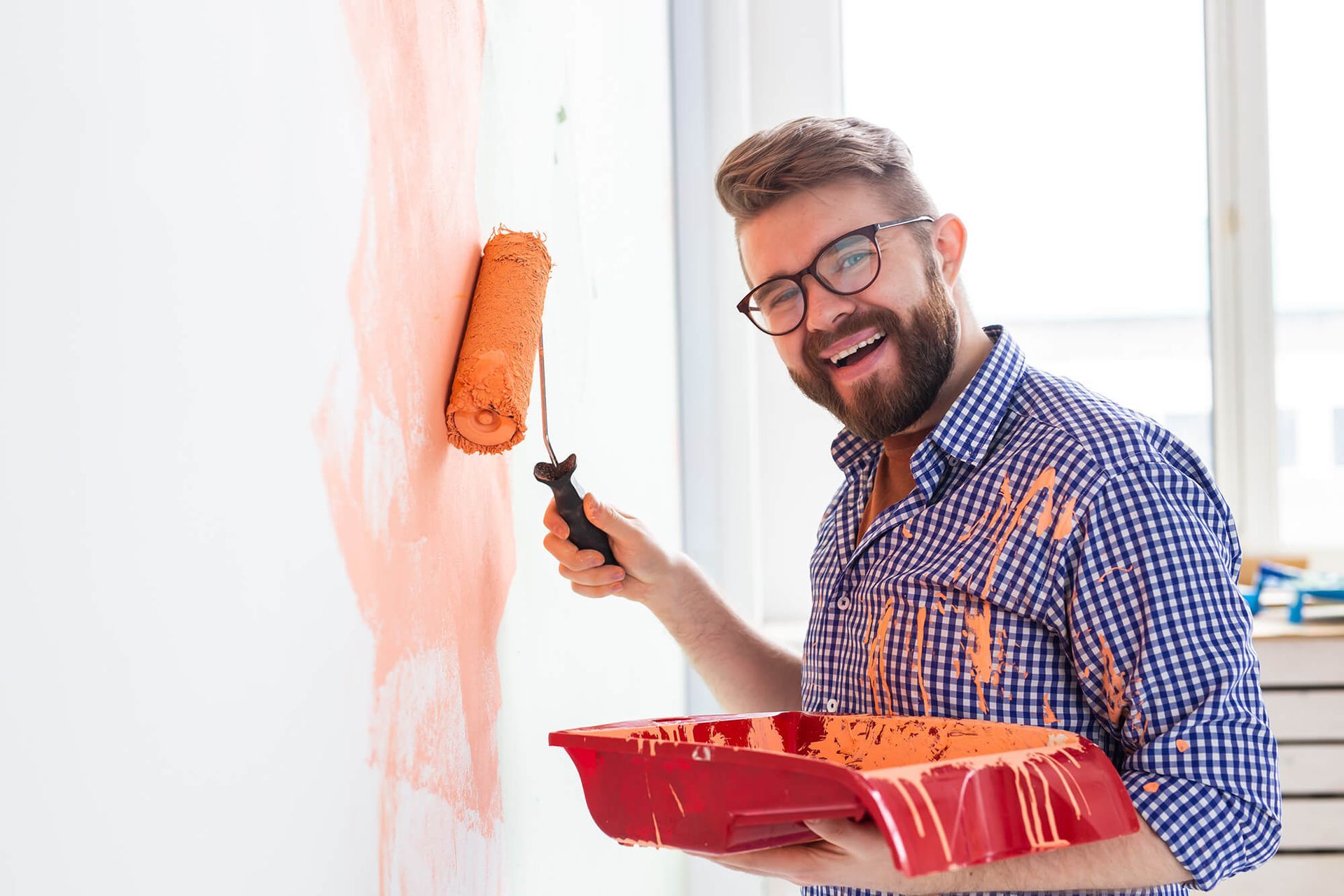 a man is painting a wall with a roller brush