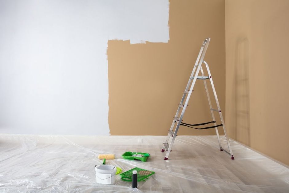 a ladder with paint supplies in a room