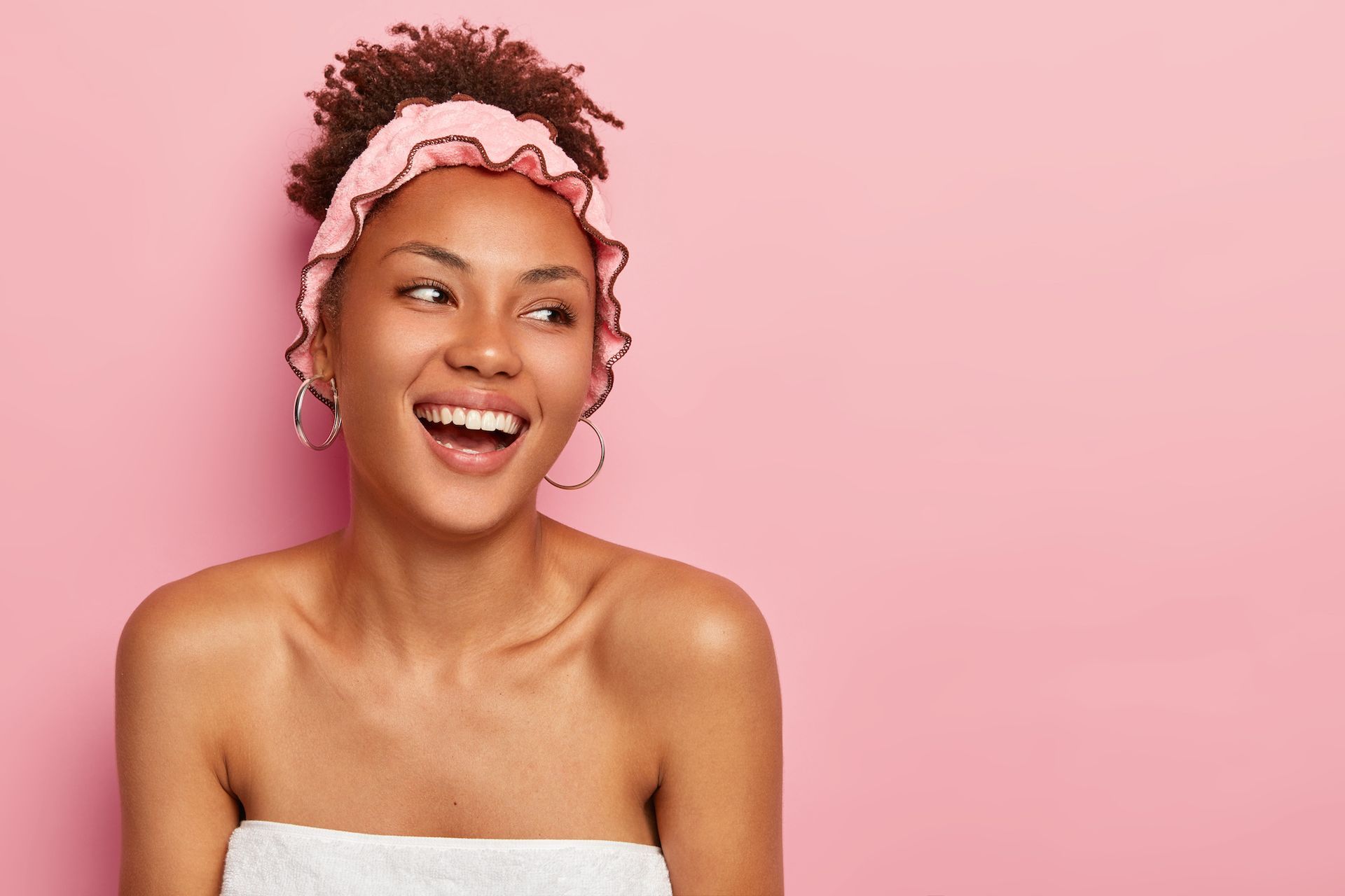 a woman with a pink headband on her head is smiling